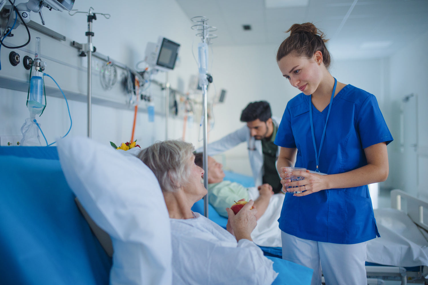 Woman in hospital bed speaking to healthcare provider